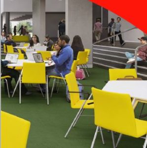 students sat in flexible learning commons space on bright furniture
